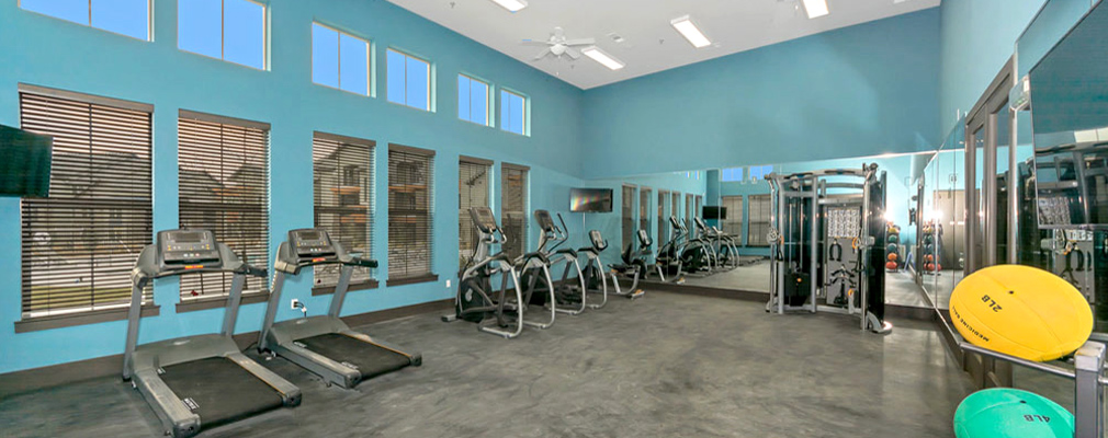 A gym with cardio equipment and a weight machine.