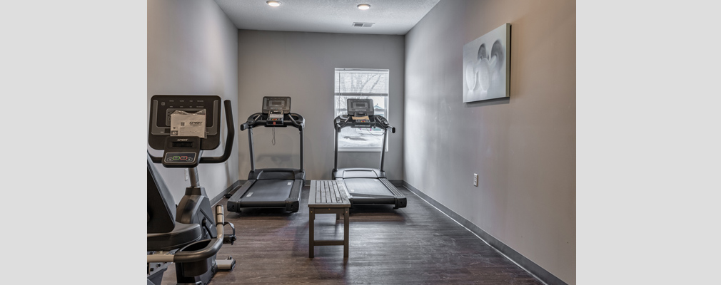 A room with two treadmills and a stationary bicycle.