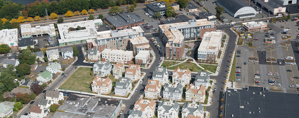 Low-angle aerial photograph of the development within the neighborhood context.