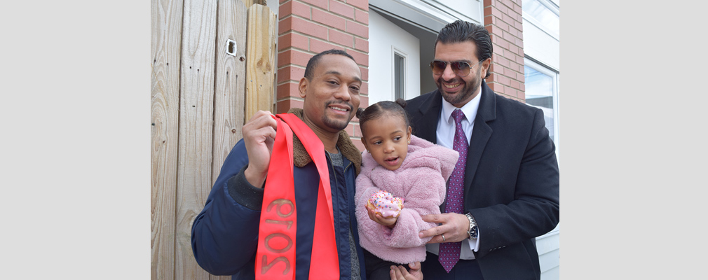 Photograph of a new homeowner and his child with the developer of Francis Villas.