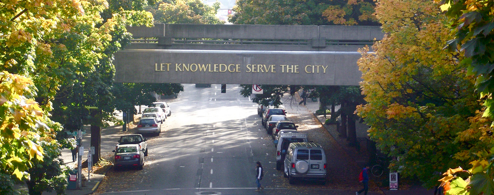 Photograph of a bridge on the Portland State University campus bearing the motto, "Let Knowledge Serve the City."