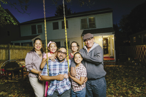 Photo shows a family of six posing in their backyard.