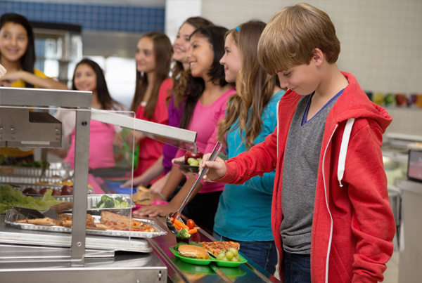 Young students line up for lunch at the school cafeteria.