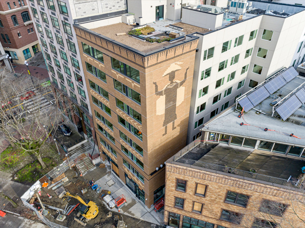 Aerial view of multistory buildings with Native artwork on one side of a building. 