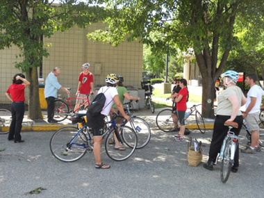 One person instructing eight cyclists on the University of Louisville campus.